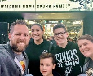 Family standing under spurs sign